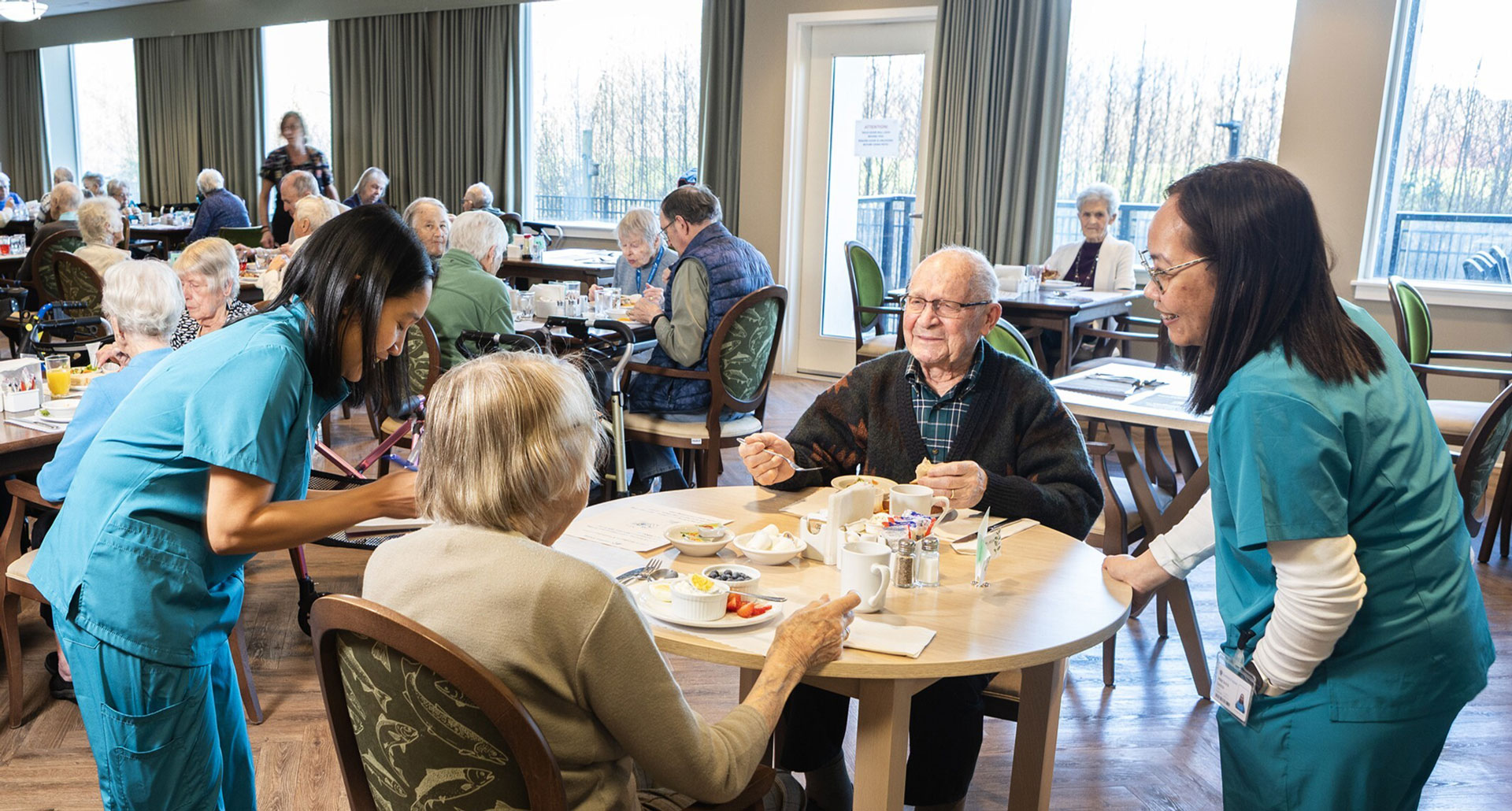 team members serving residents in dining area